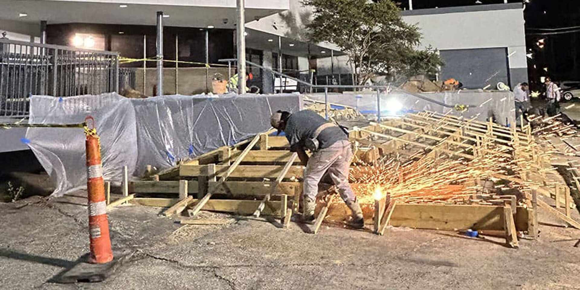 Worker welding on framework at night